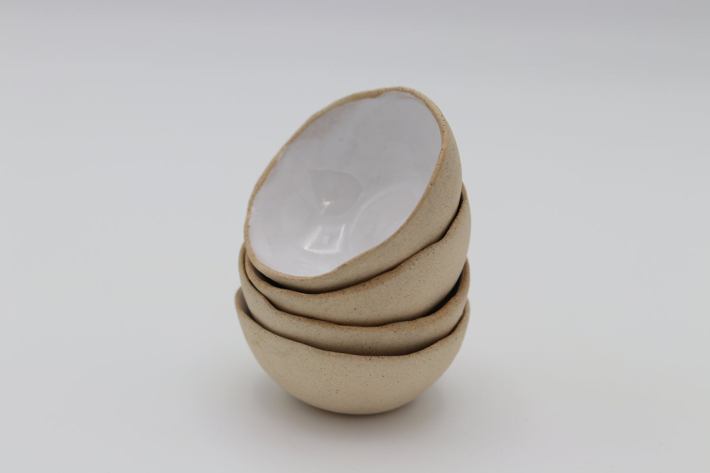 a stack of white glazed ceramic stacking mini bowls