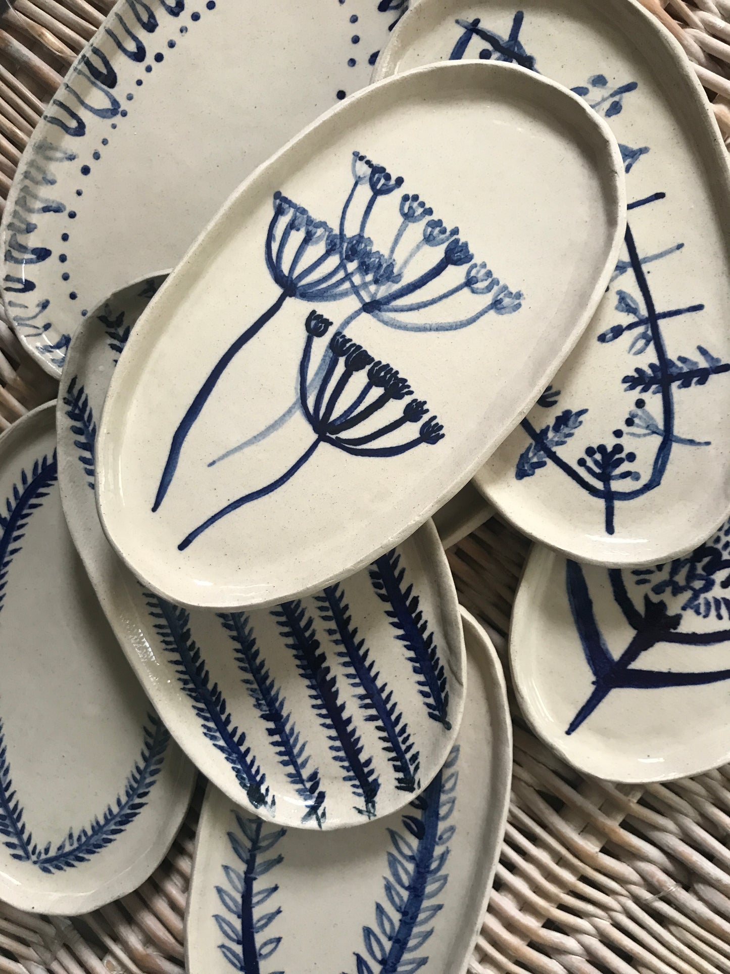 Natural stoneware glazed ceramic oval side plate with hand painted blue leaf garland floral design