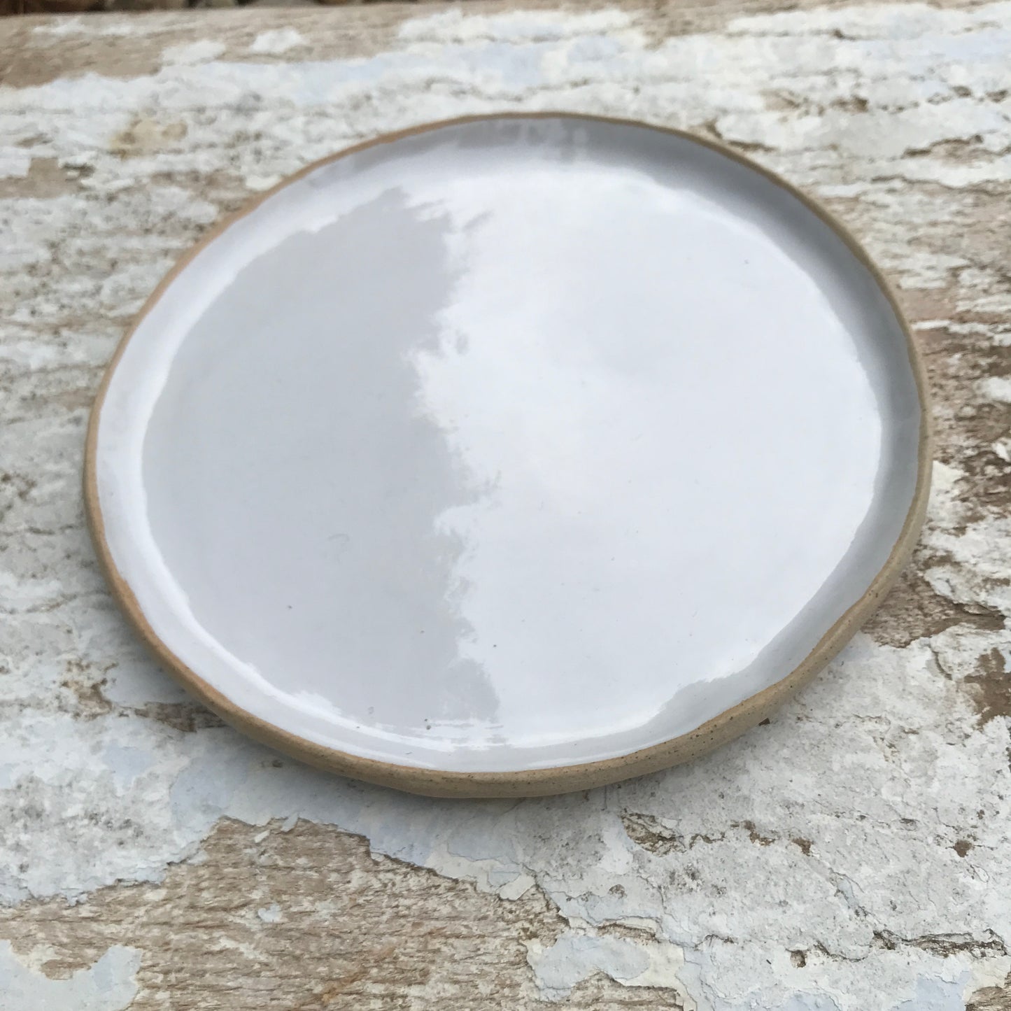 White glazed hand shaped ceramic plate with raw clay toasted rim edge