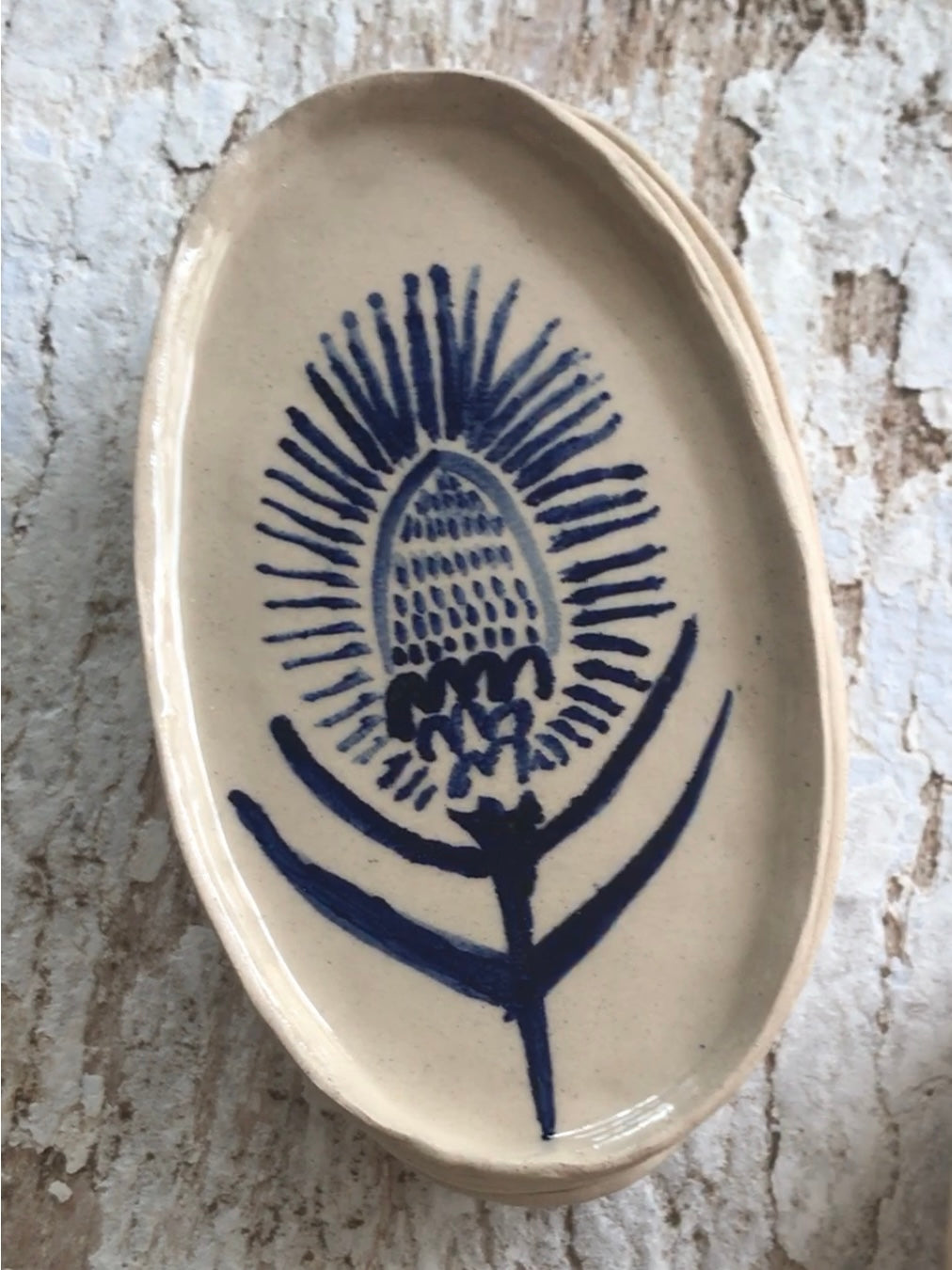 Natural stoneware glazed ceramic oval side plate with hand painted blue leaf garland floral design