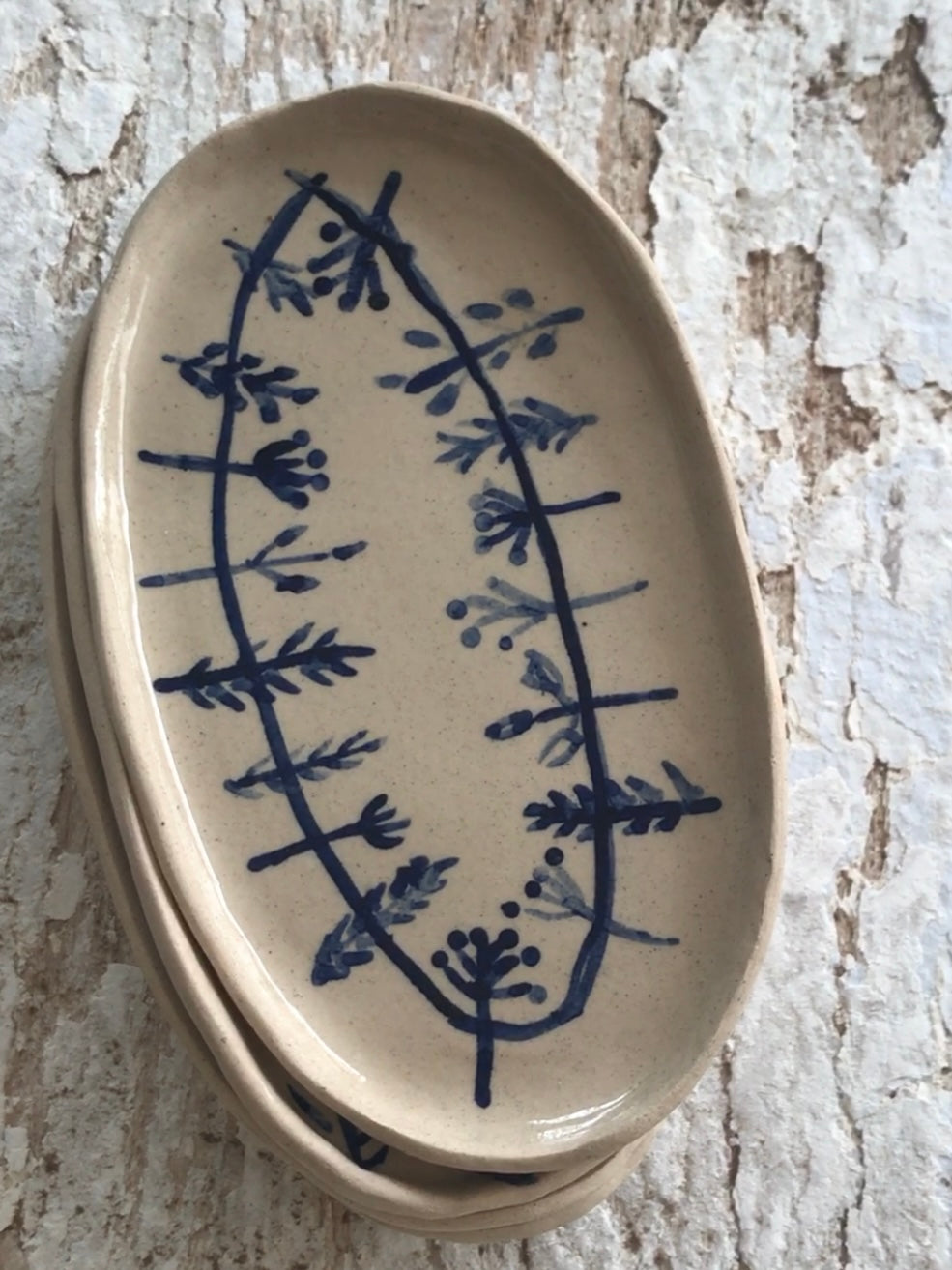 Natural stoneware glazed ceramic oval side plate with hand painted blue leaf garland floral design