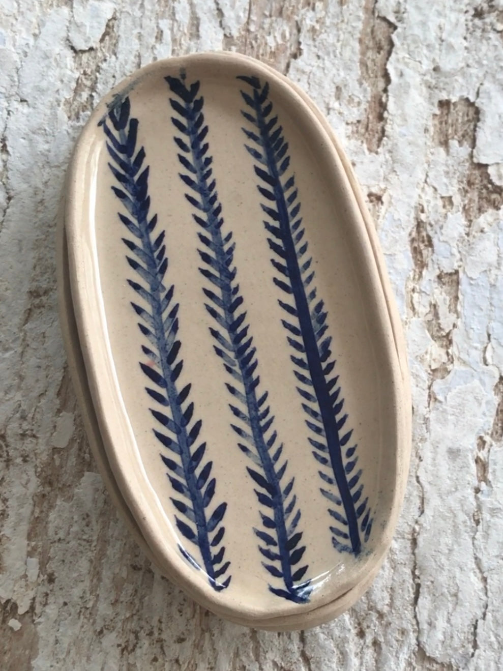 Natural stoneware glazed ceramic oval side plate with hand painted blue leaf garland floral design