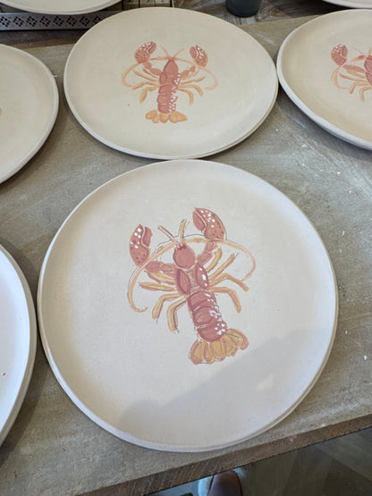 Multiple handmade ceramic lobster plates in pottery studio