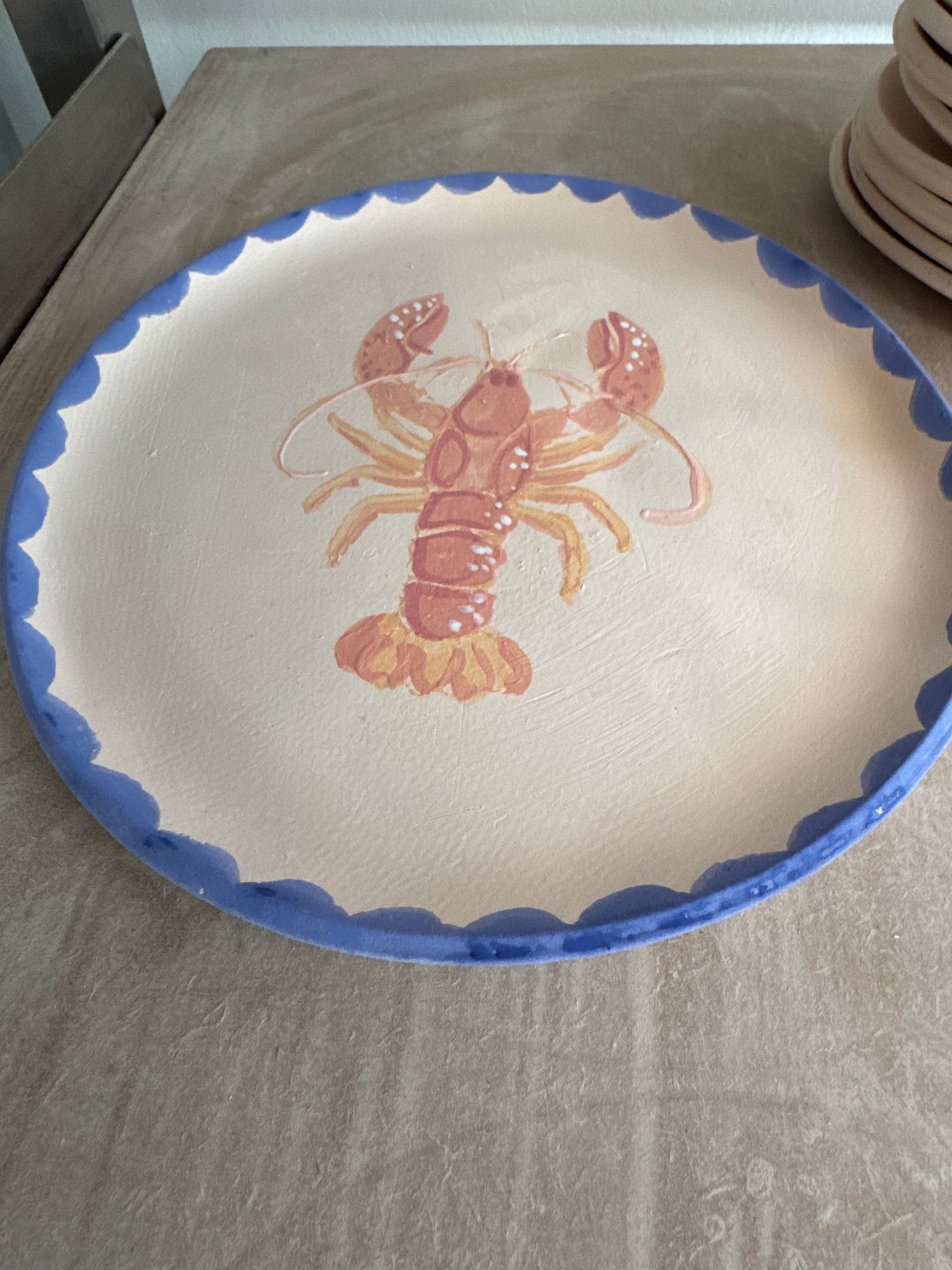 Handmade ceramic lobster platter with cobalt blue scalloped edge