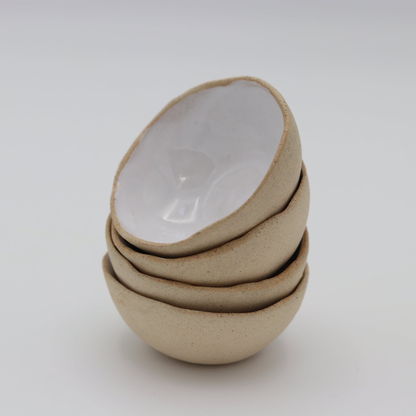 a stack of white glazed ceramic stacking mini bowls 